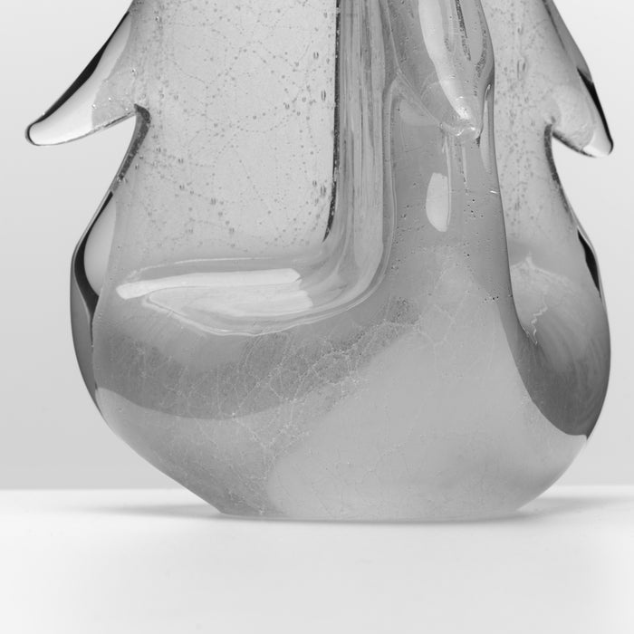 Clear glass candle with organic petal-shaped form and speckled texture throughout.