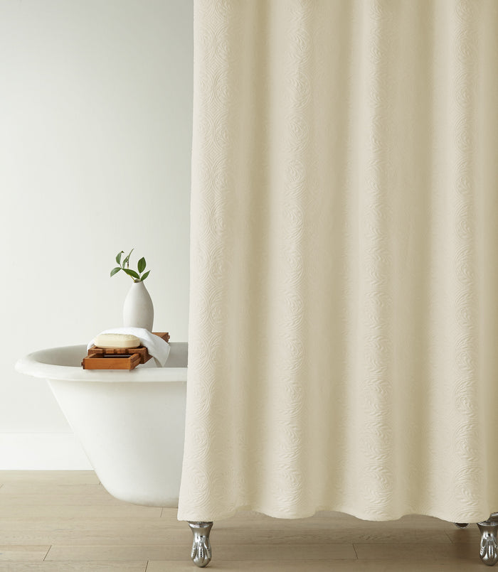 Vienna Matelassé Shower Curtain in a bathroom setting with a white bathtub and decorative items, Ivory