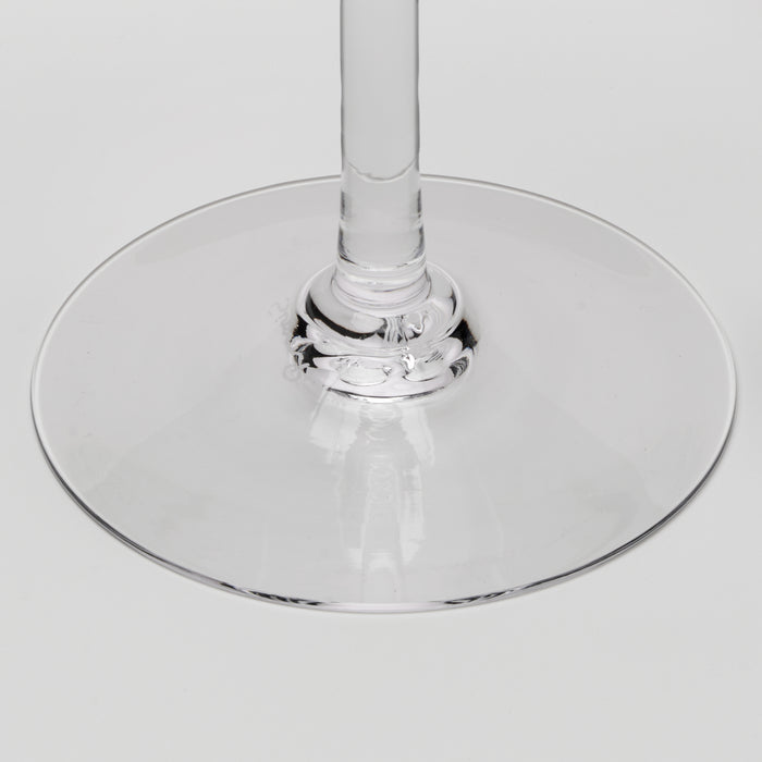 Close-up of a clear glass wine glass base and stem on a light gray background.