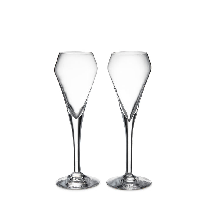Two clear glass champagne flutes with tapered bowls and thin stems on round bases.