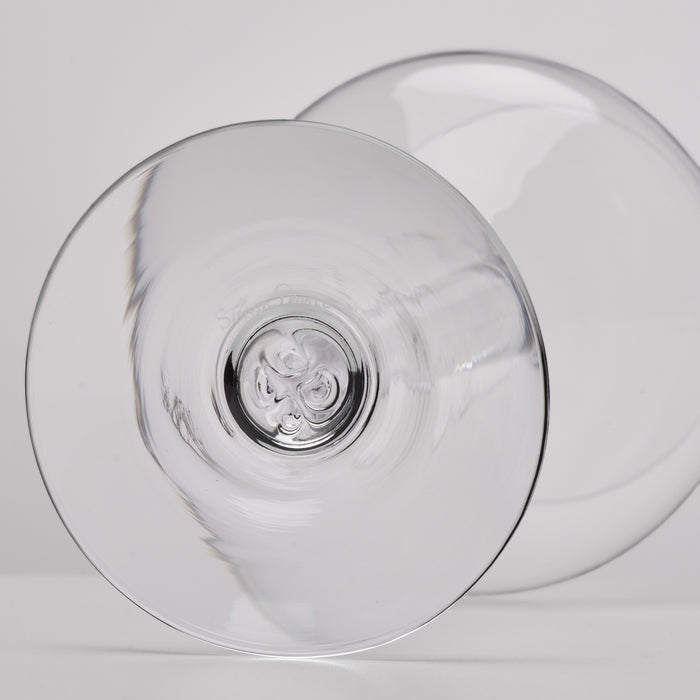 A clear glass shown from the bottom on a light gray background.