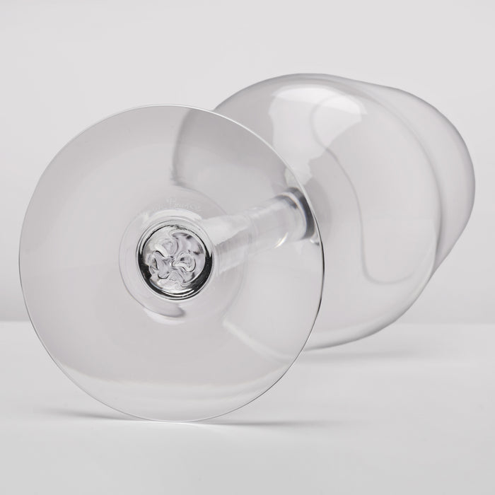 A clear glass wine glass shown from a side angle on a light gray studio background.