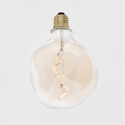 Large globe-shaped LED bulb with tinted clear glass, brass base, and curved filament detail inside.