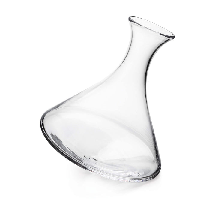 Clear glass wine decanter with curved body and angled spout, tilted at an angle.