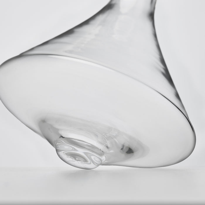 Clear glass wine decanter with curved bowl shape and tapered spout, shown at an angle.