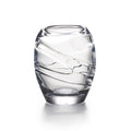 Clear glass tumbler with curved diagonal ridges throughout the body and thick base.