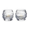 Two clear glass tealight holders with textured wrap design, each containing a small cream-colored candle.