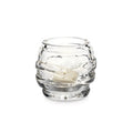 Clear glass tealight holder with textured horizontal bands and a cream-colored candle inside.