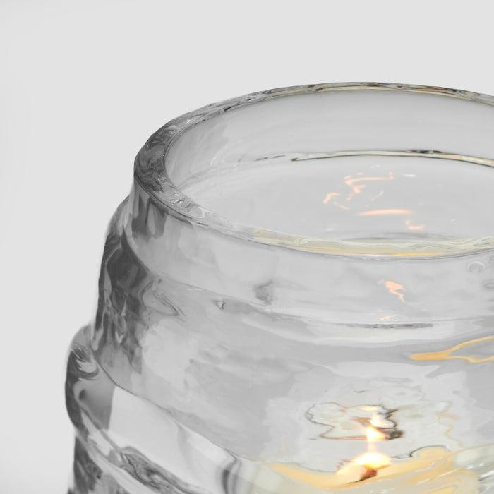 Frosted glass tealight holder with marble swirl pattern and lit candle inside.