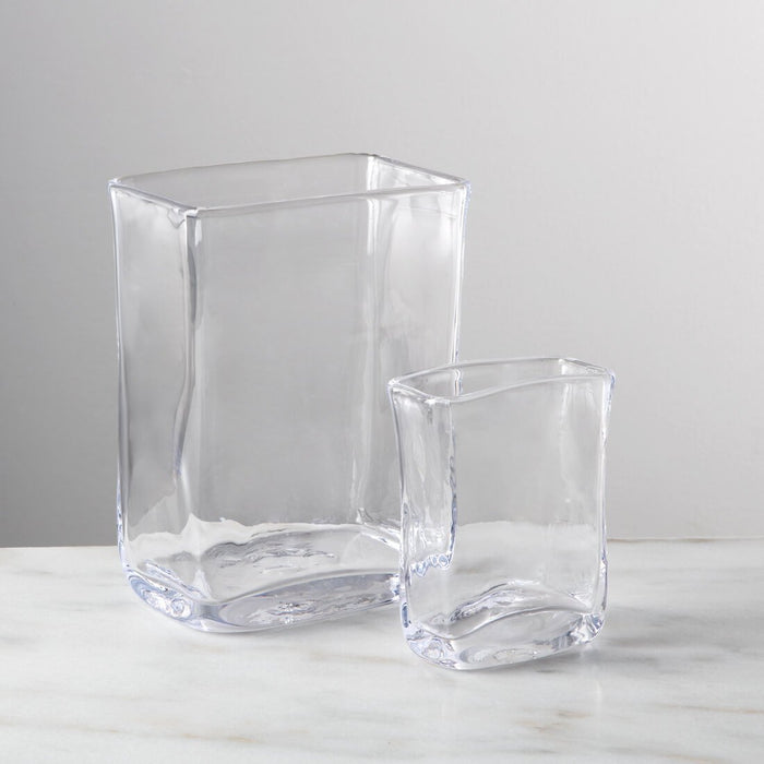 Two clear glass rectangular vases in different sizes with curved sides and rounded bases.