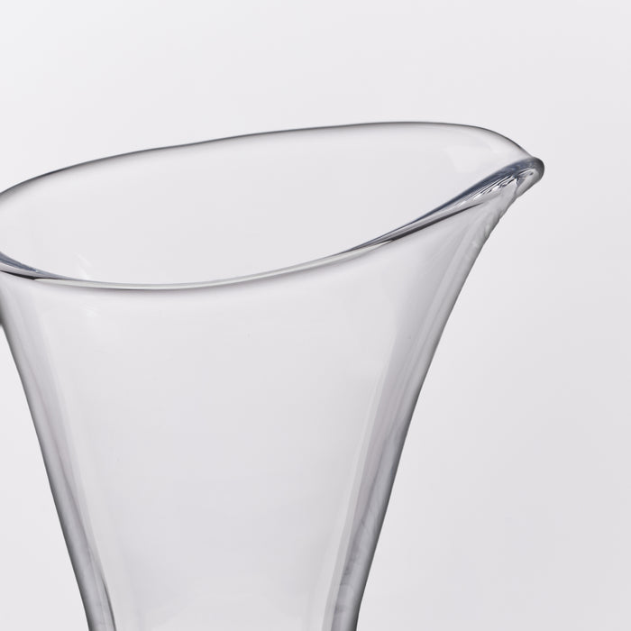 Clear glass cocktail coupe with tapered sides and a wide curved rim.