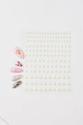 Sheet of white pearl nail stickers and four sample nails with pearl, leopard, and glitter designs.