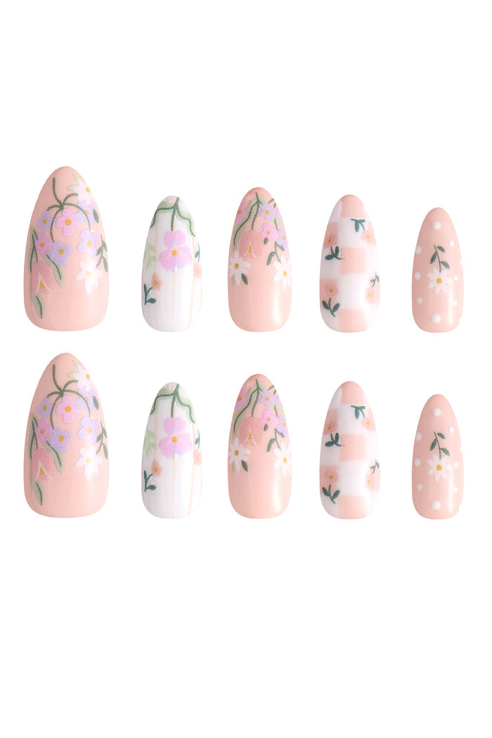 Wildflower Picnic press-on nails feature floral designs and gingham patterns on a peachy pink base.