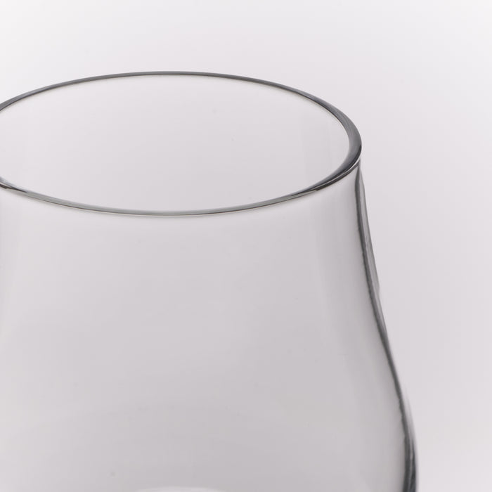 Close-up of a clear glass vessel, showing the rim and upper body against a light gray background.