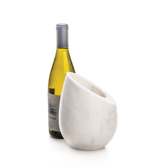 White marble wine chiller with curved bowl shape holding a wine bottle with yellow liquid inside.