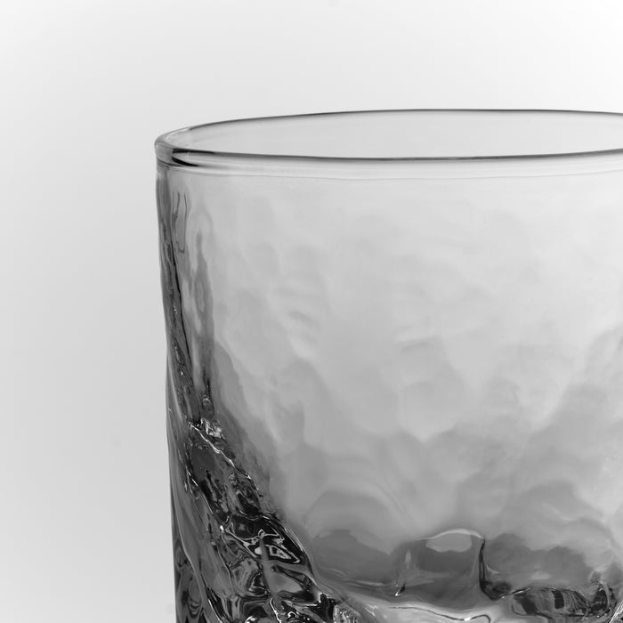 Clear glass tumbler with textured base and smooth rim.