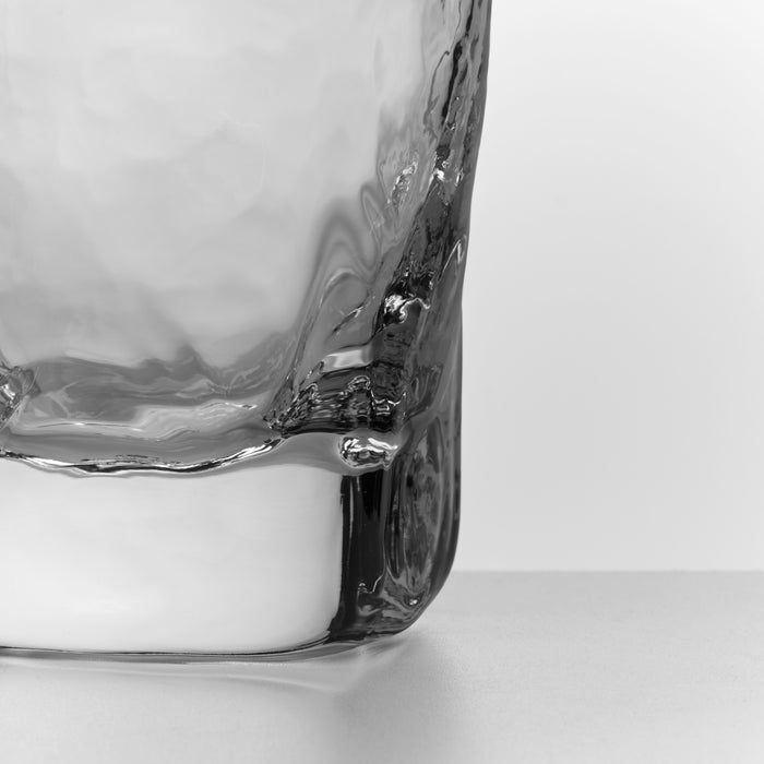 Glass filled with water and ice cubes against white background.