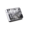 Black and white photo block with cityscape image featuring tall buildings and cloudy sky.