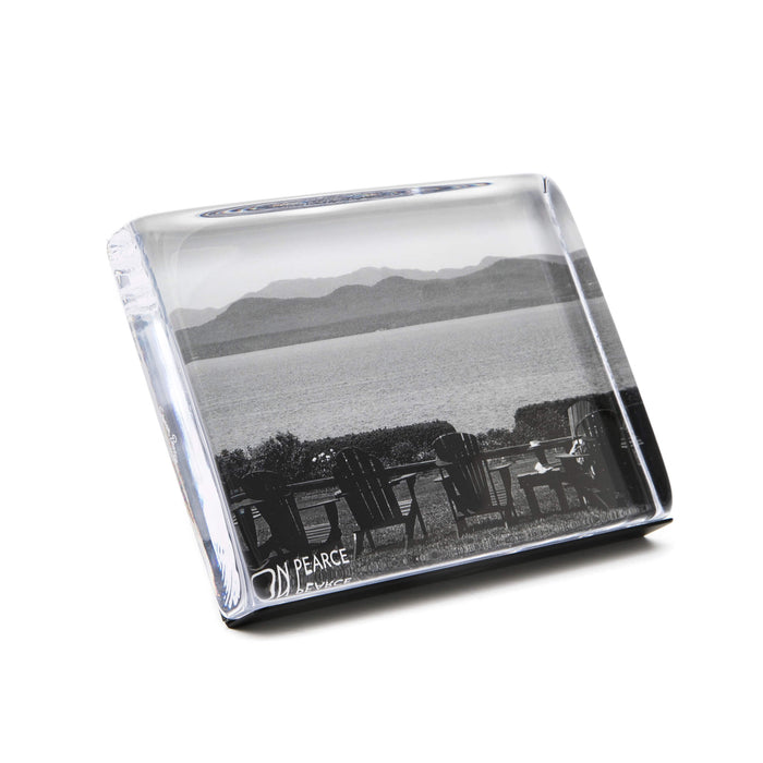Clear acrylic photo block with black and white landscape image of lakeside chairs and mountain view.