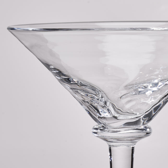 Close-up of a clear glass martini glass with a textured, wavy pattern on the bowl and stem, set against a light gray background.
