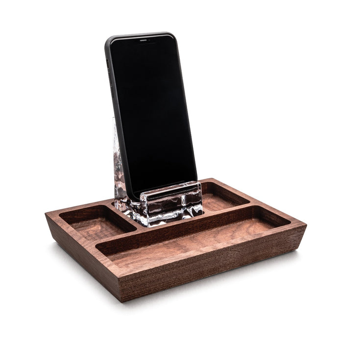 Walnut wood caddy with rectangular compartments holding a smartphone in a clear acrylic stand.