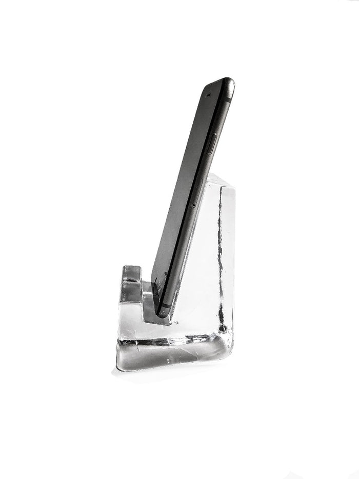 Black smartphone resting in clear acrylic stand with angled support base.