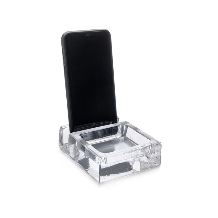 Clear acrylic phone stand with shallow tray base and angled slot to hold smartphone upright.