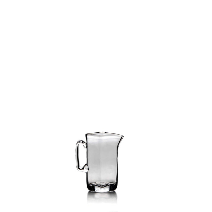 Clear glass pitcher with a curved spout, handle, and slightly tapered rectangular body.