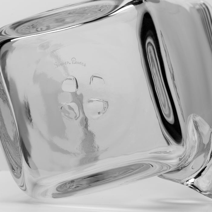 Clear glass pitcher with a handle, featuring embossed decorative design on the front panel.