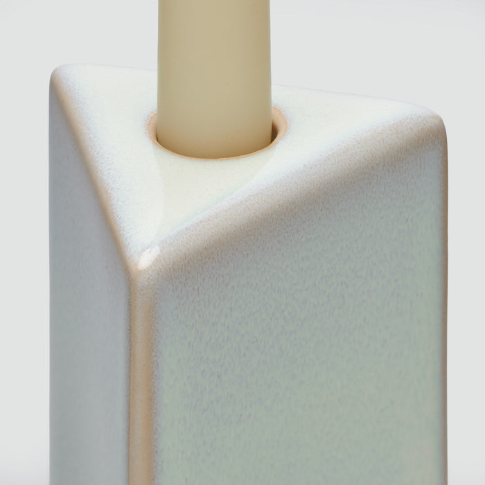 Cream-colored ceramic taper holder with cylindrical opening at top and angular geometric body.
