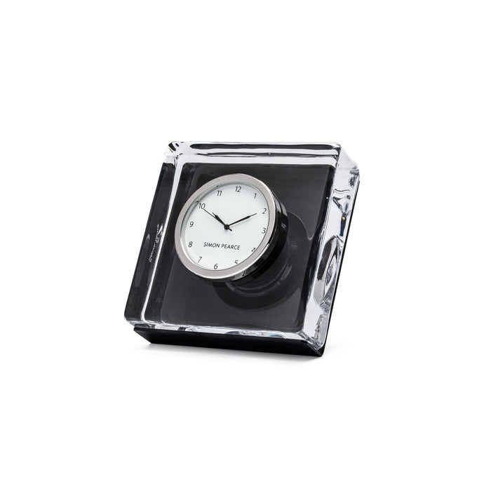 Square desk clock with white face and black hands, mounted in clear acrylic case with black base.