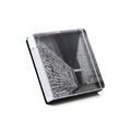 Clear acrylic photo block with white edge and black stand, displaying black and white architectural photograph of brick build