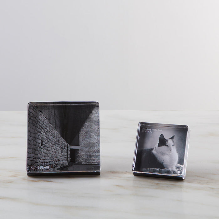 Two square acrylic photo blocks displaying black and white images, with the larger block on the left and smaller block on the