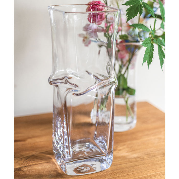 Clear glass vase with twisted mid-section design, rectangular shape, displayed on wooden surface.