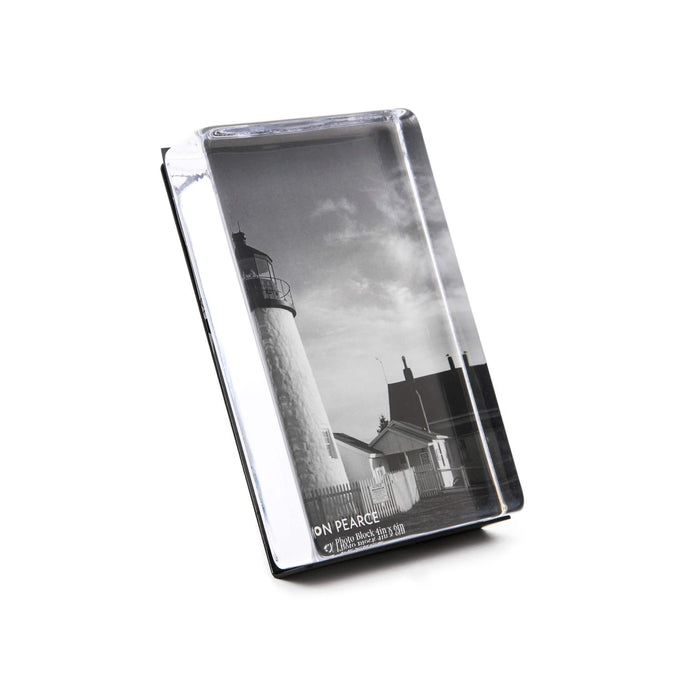 Vertical acrylic photo block displaying a black and white lighthouse image with attached stand.