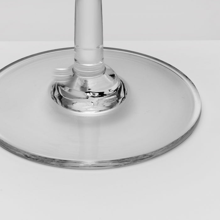 Close-up of a clear glass base and stem on a light gray background.
