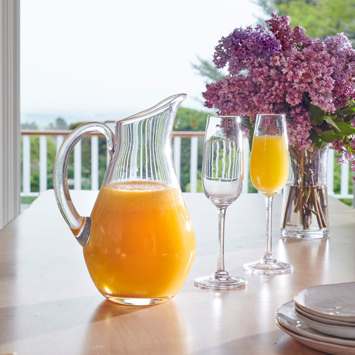 I notice this image shows a table setting with a pitcher of juice, glasses, and flowers—not flutes or a gift box as described