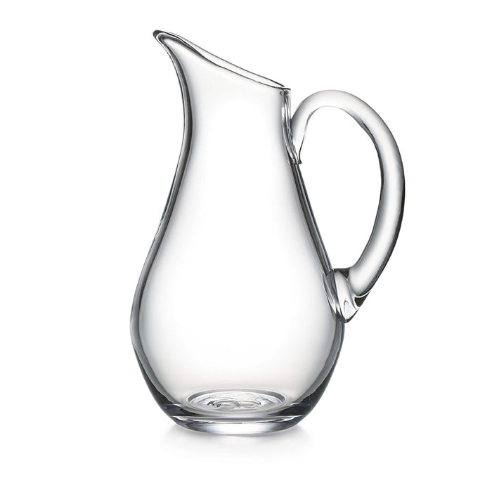 Clear glass pitcher with curved body, angled spout, and large handle.