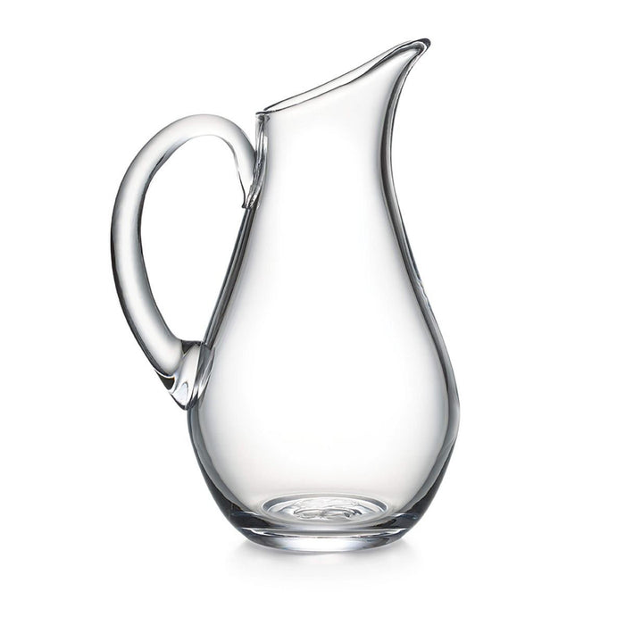 Clear glass pitcher with curved body, angled spout, and thick handle.