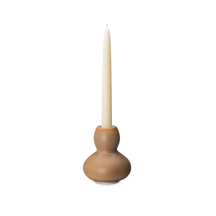 Tan ceramic candlestick holder with bulbous base holding a cream taper candle.