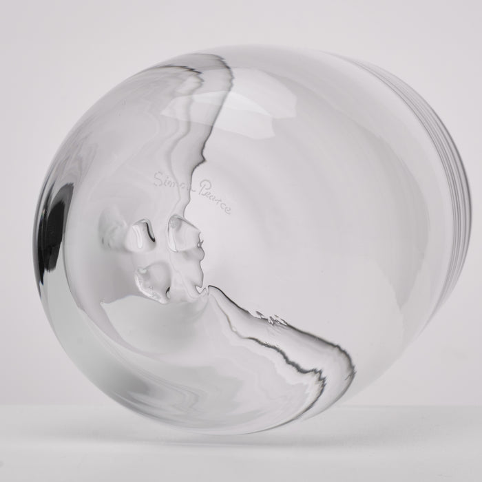 A clear glass photographed against a light gray studio background.